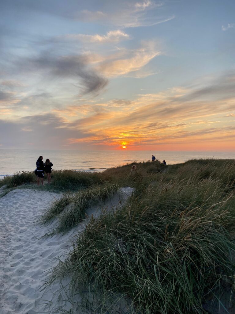 Kitesurfer op Vlieland geniet van een kitesurfles met blauwe lucht en golven