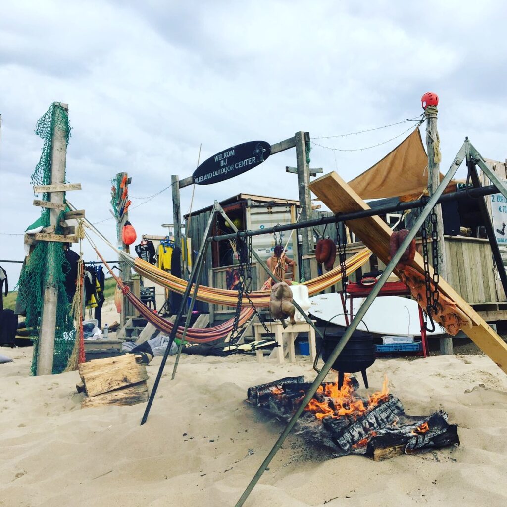 Kitesurfen op Vlieland geniet van een kitesurfles met blauwe lucht en golven